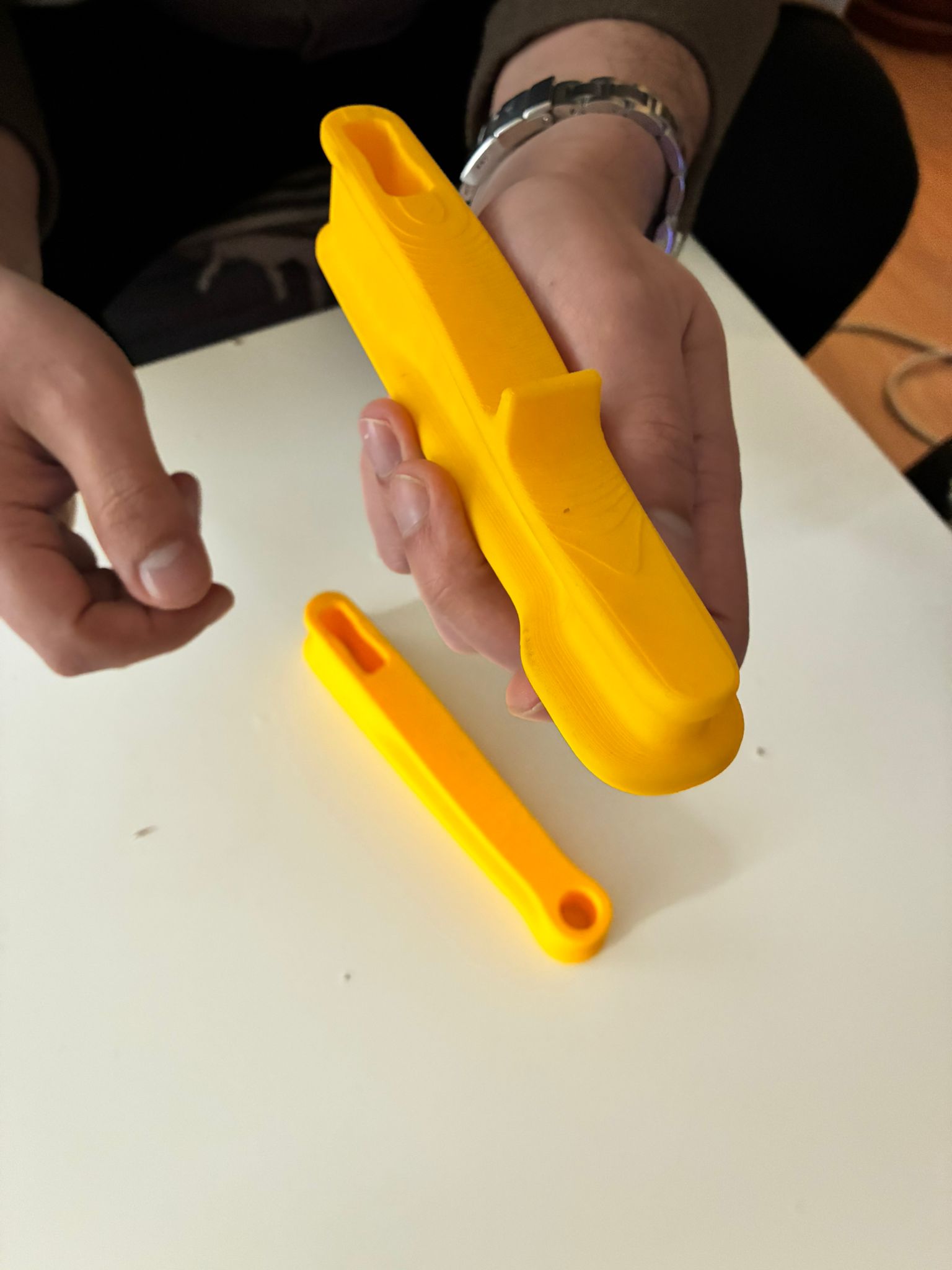 Close-up hand test of the yellow Bulut F-Clamp prototype handle