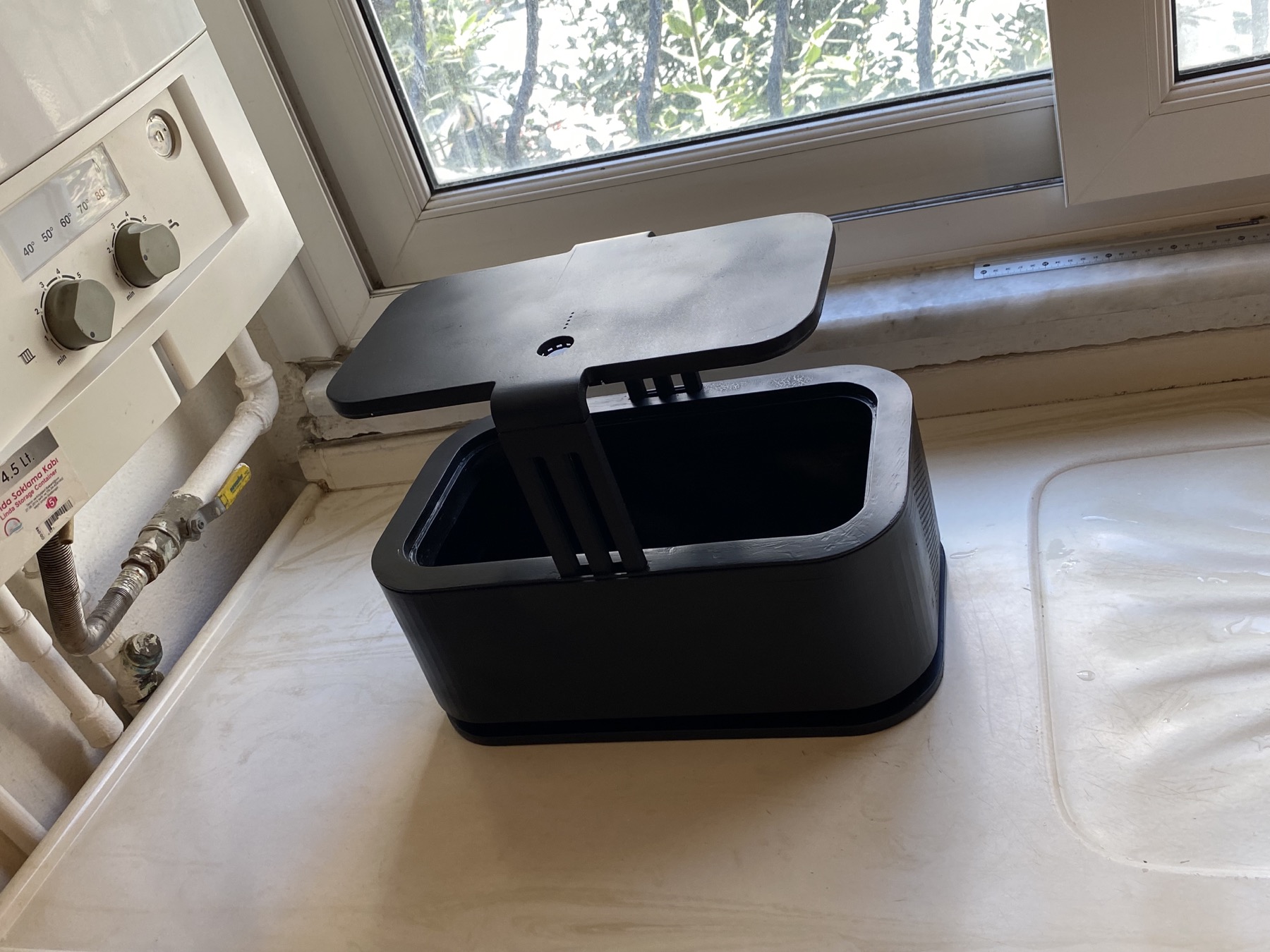 Black Rhodark prototype shell on a windowsill during physical evaluation